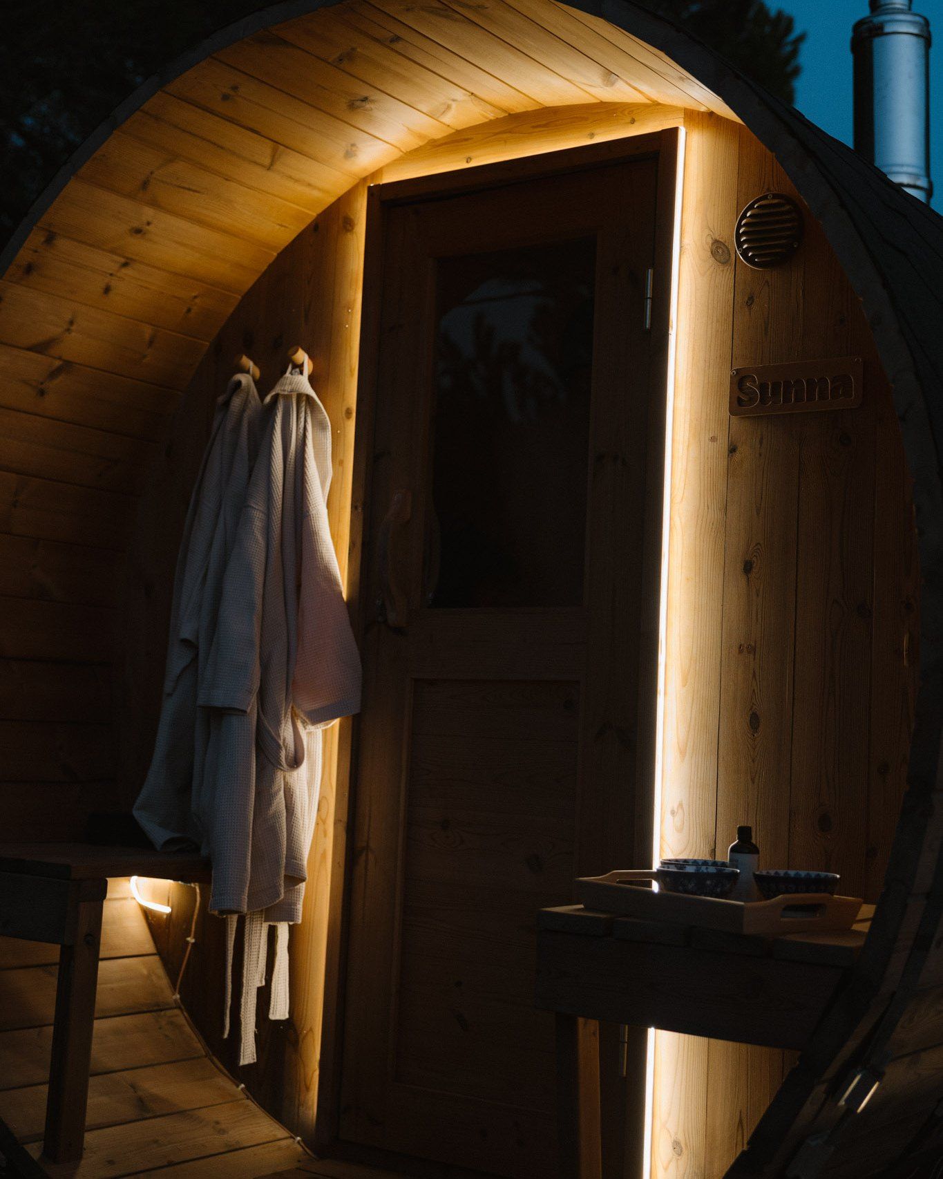 The barrel sauna lit in the evening at Atlas Cove (photo credits Atlas Cove)