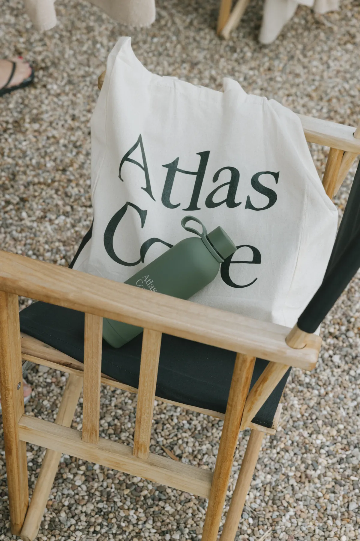 An Atlas Cove tote and water bottle on a wooden chair